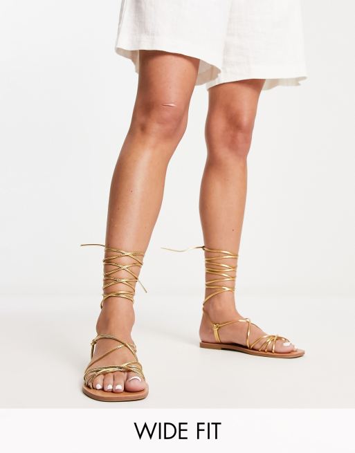London Rebel - Wide Fit - Flade guldfarvede sandaler med bindebånd om benet
