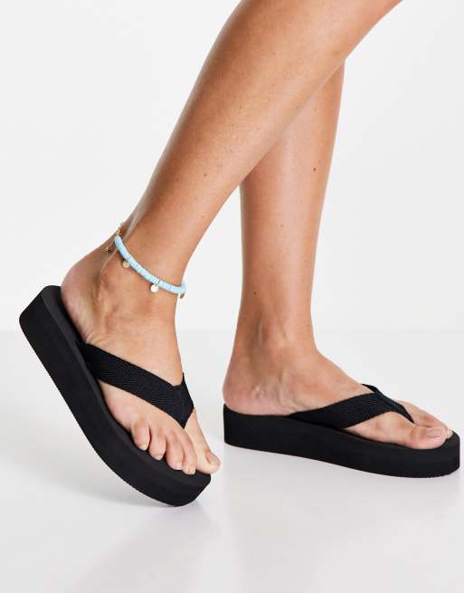 London Rebel – Zehenstegsandalen in Black Drench