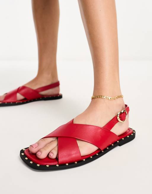 Love Moschino – Czerwone sandały na płaskiej podeszwie ze skrzyżowanymi paskami i ćwiekami