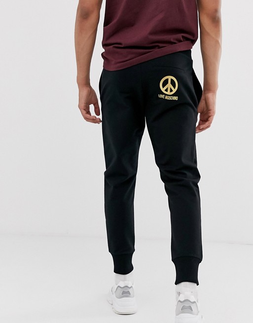 Love Moschino joggers in black with gold peace logo
