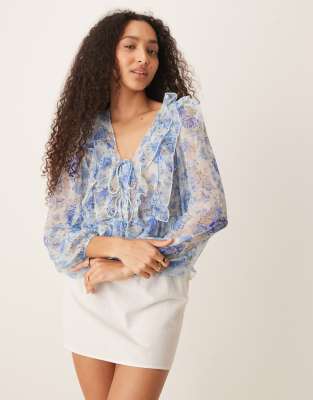 Mango - Langärmlige Bluse in Pastellblau mit Rüschendetails, Bindeband und Blumenmuster