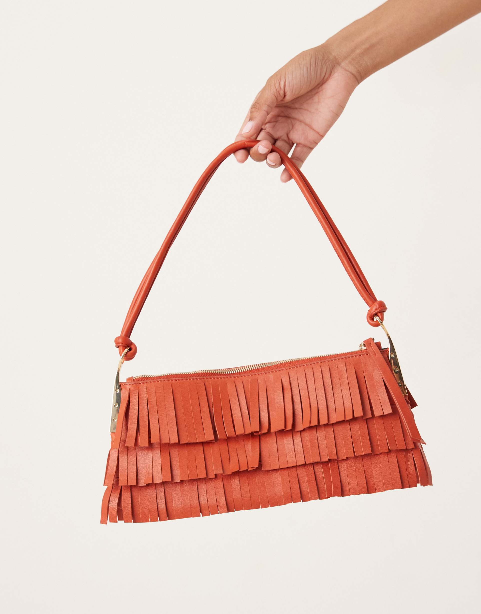 mango leather fringed hand bag with gold accents in rustic red