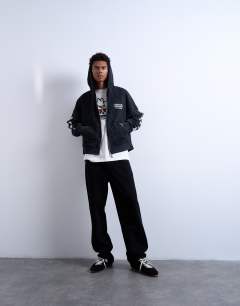 Model wearing Mason Newman x Topman boxy fit hoodie with cowgirl front and back print in washed black