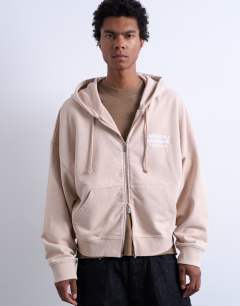 Model wearing Mason Newman x Topman boxy fit hoodie with hotel bar front and back print in washed stone