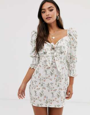 Minivestido blanco con hombros abullonados, lazo delantero y estampado floral de In The Style x Laura Jade
