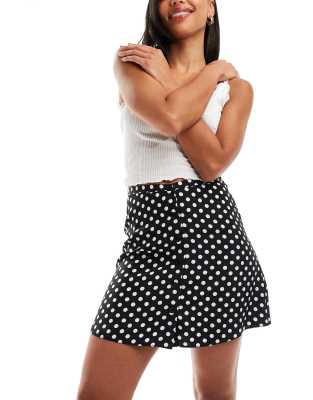 button through flippy mini skirt in black polka dot