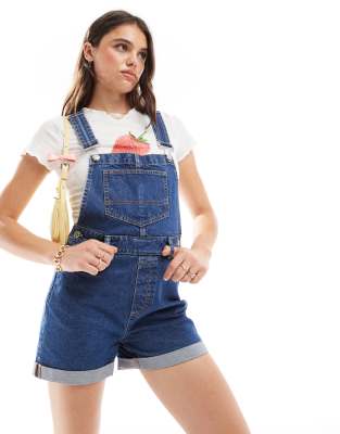 overall denim shorts in mid blue wash