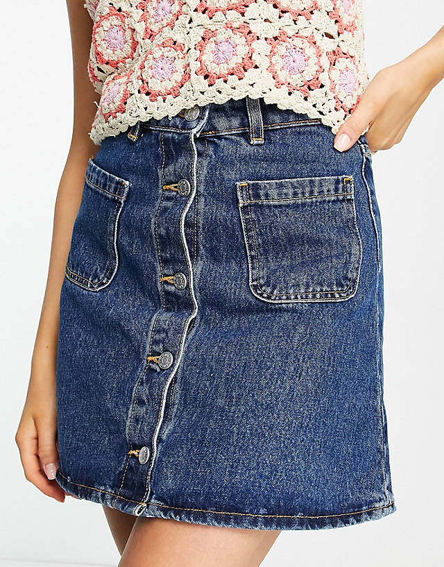 Monki - button through mini skirt with front pockets in mid wash denim