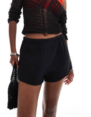 Monki crinkle textured pull on elastic waistband shorts in black