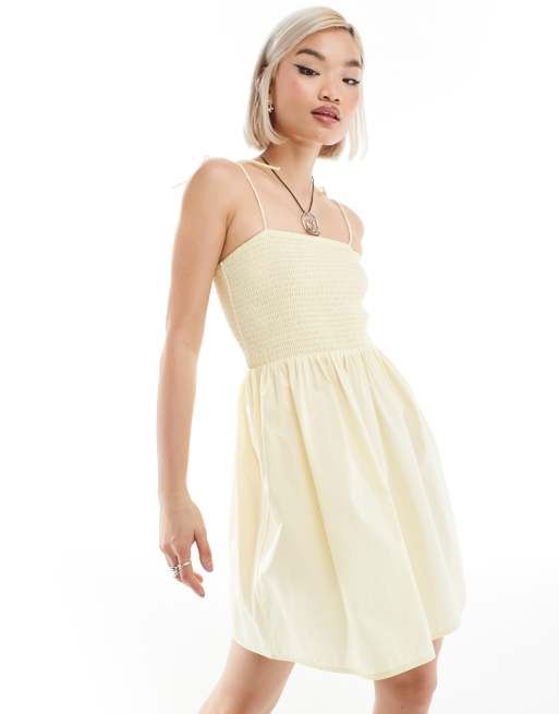 Monki – Gul miniklänning i babydoll-design med smockad bandeauringning