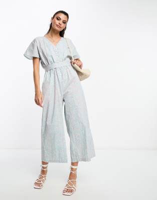 Monki - Kurzärmliger Jumpsuit in Blau mit Punktmuster, Bindegürtel und V-Ausschnitt