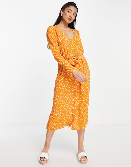 Monki – Langärmliges Midikleid in Orange mit Gänseblümchenmuster und Bindeband vorne