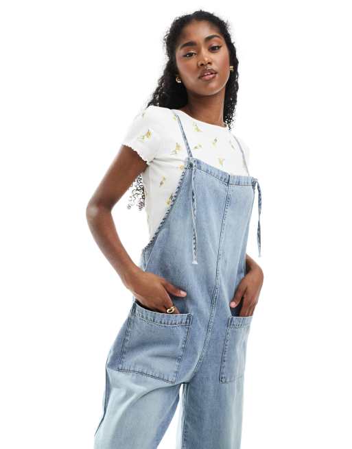 Monki – Latzhose aus Denim in hellblauer Waschung mit Bindedetail