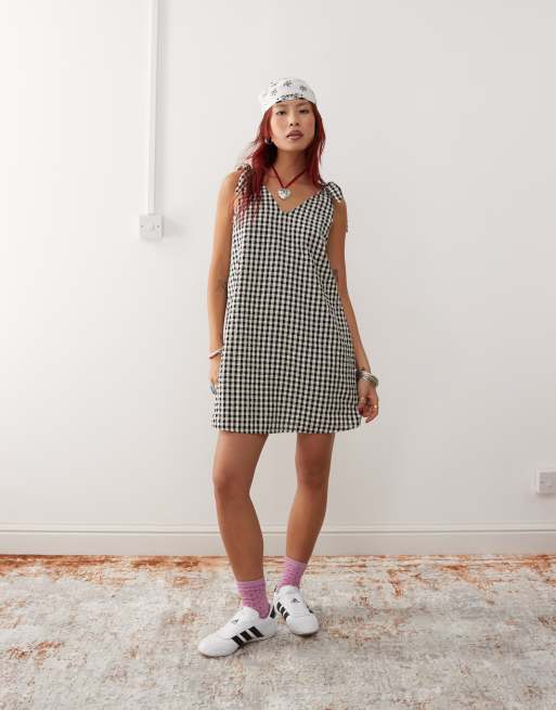 Monki - Minikjole med bindestropper og sidelommer i seersucker med sorte og hvide gingham-tern