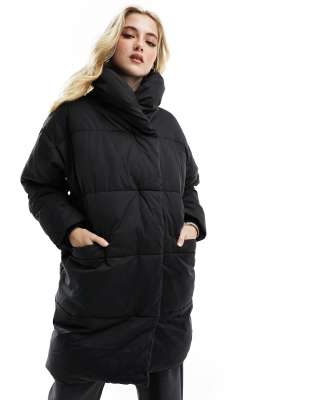 Monki - Wattierte und lang geschnittene Jacke in Schwarz mit Oversize-Passform