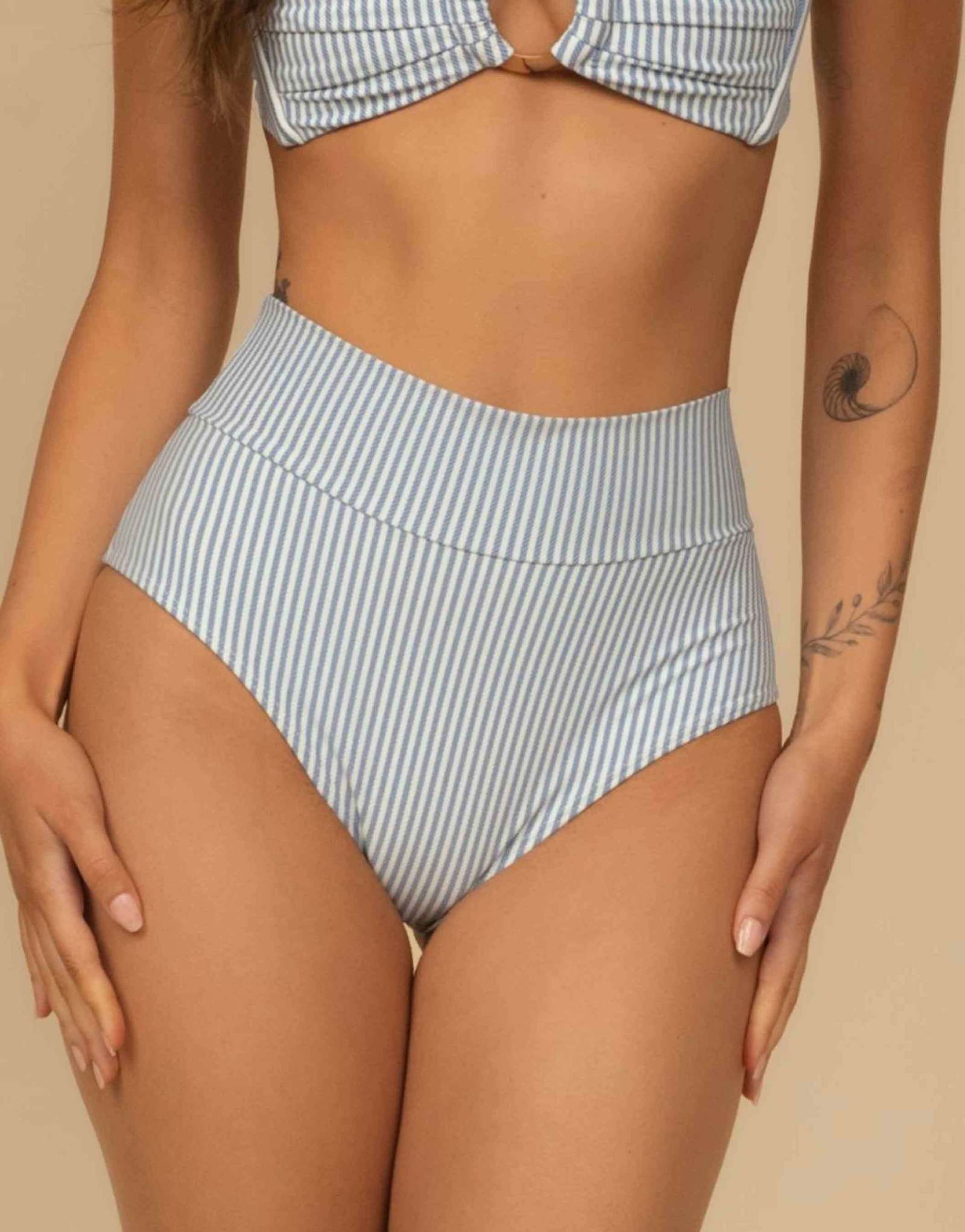 Модель MONTCE дополнила облегающий купальник-бикини с высокой посадкой в классическую синюю полоску