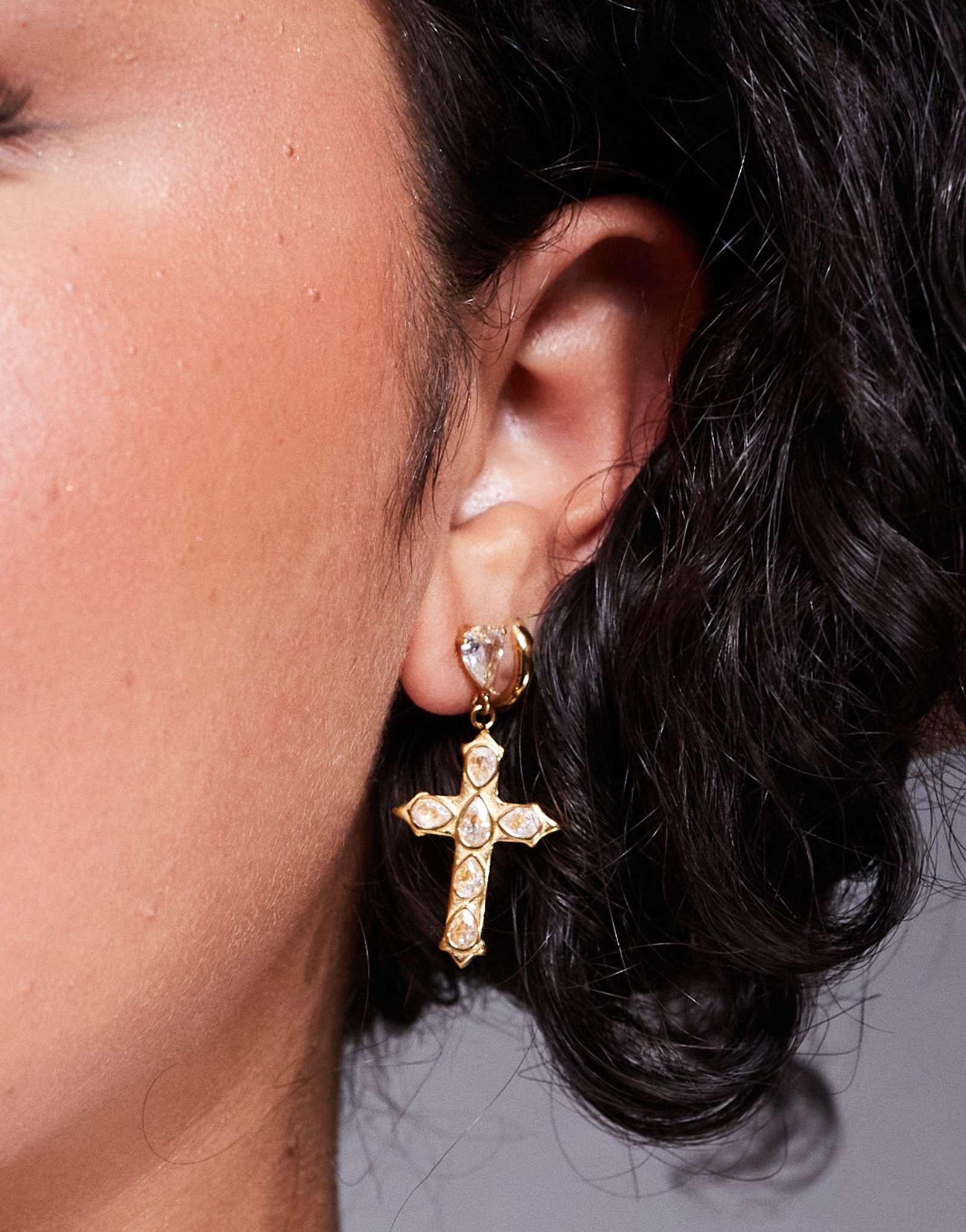 Серьги-крестики из прозрачного камня на прямой шее в золотой оправе