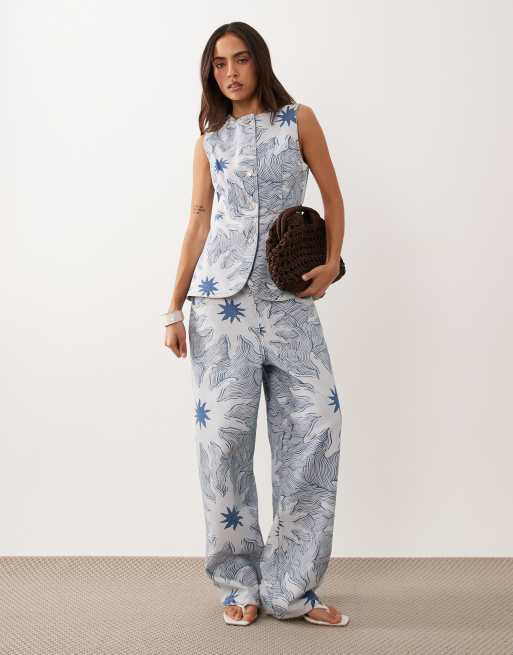 Never Fully Dressed - Ellie - Coordinato in twill di denim blu con stampa soleil composto da gilet taglio lungo e pantaloni