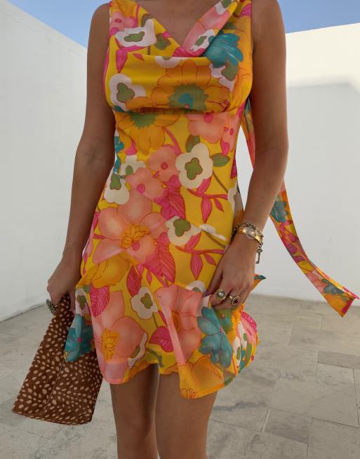 Never Fully Dressed - Sophie - Gul minikjole i chiffon med blomstermønster og tørklædedetalje samt vandfaldsudskæring, 2 af 4