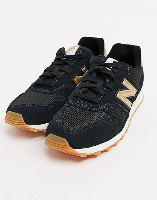 New Balance 373 trainers in black & gold