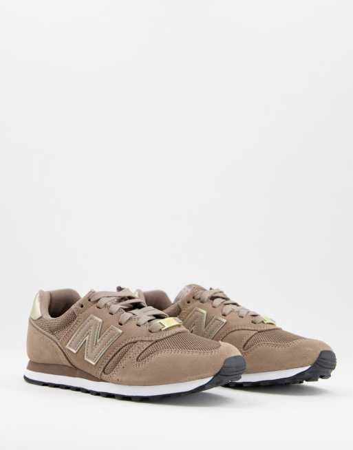 New Balance 373 trainers in brown and gold