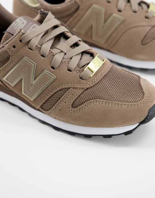 New Balance 373 trainers in brown and gold