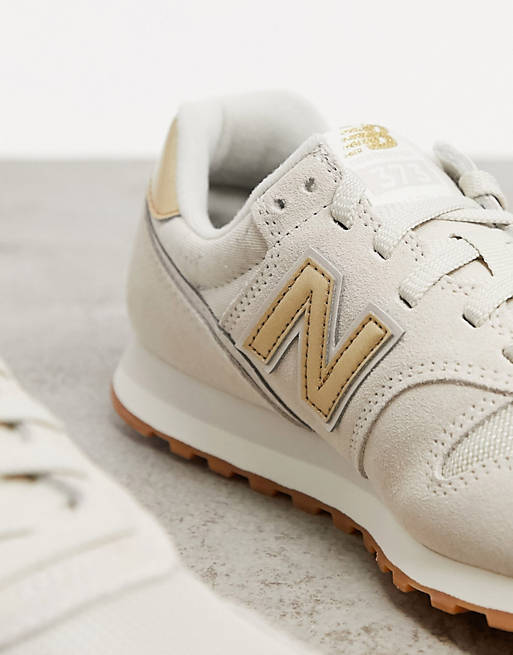 New Balance 373 trainers in cream and gold