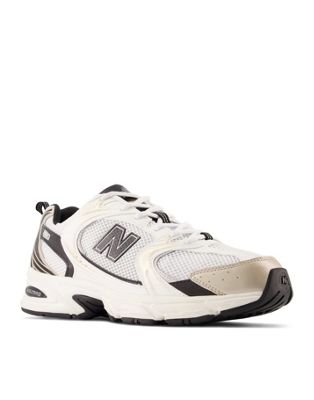 New Balance 530 trainers in white with black and gold detailing