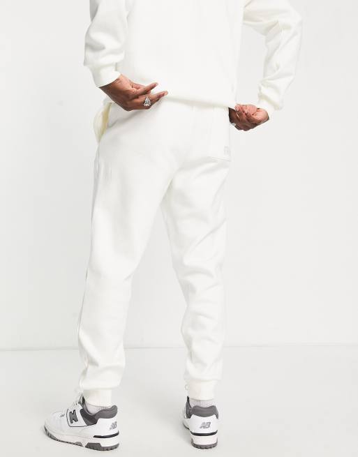New Balance 'Elevate Yourself' unisex track pants in off white