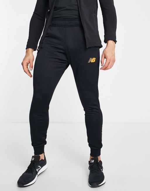 New Balance – Football Graft – Schmal geschnittene Jogginghose in Schwarz und Orange, exklusiv bei ASOS 