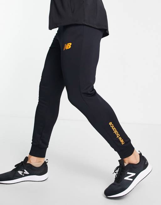 New Balance Football graft slim fit joggers in black and orange exclusive to ASOS