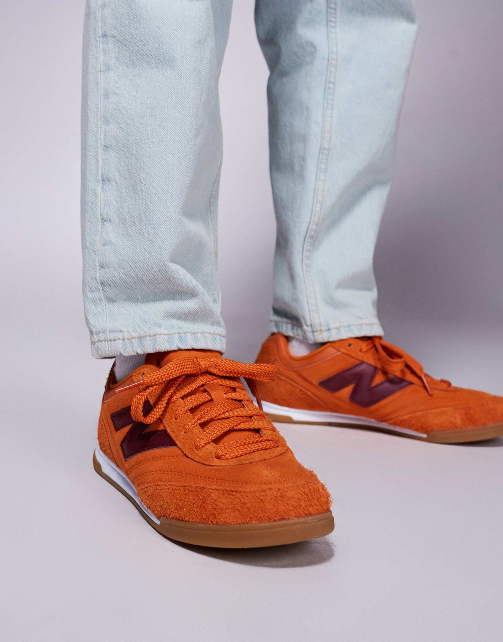 Оранжевые кроссовки New Balance RC42 на резиновой подошве с фиолетовыми деталями