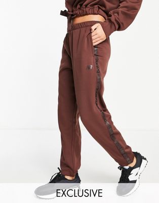 New Balance Running Joggers with logo taping in bitter chocolate exclusive to ASOS
