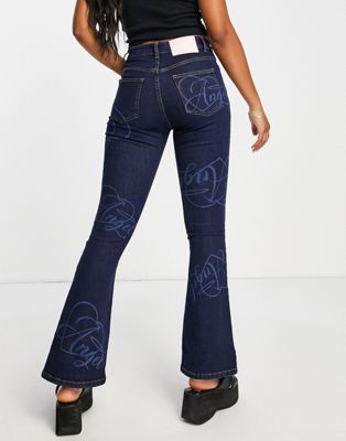 New Girl Order low rise flared jeans with angel in blue mid wash