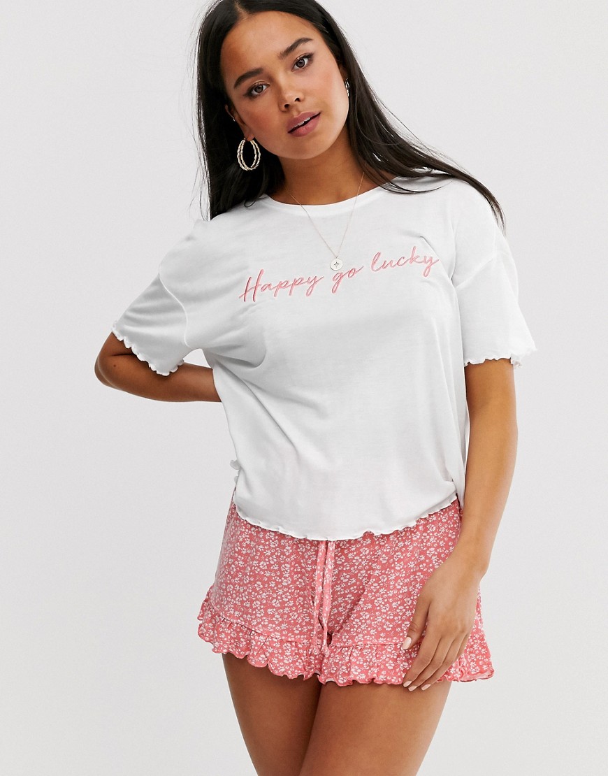 New Look – Korallrosa pyjamas med shorts och t-shirt med texten happy go lucky-Orange