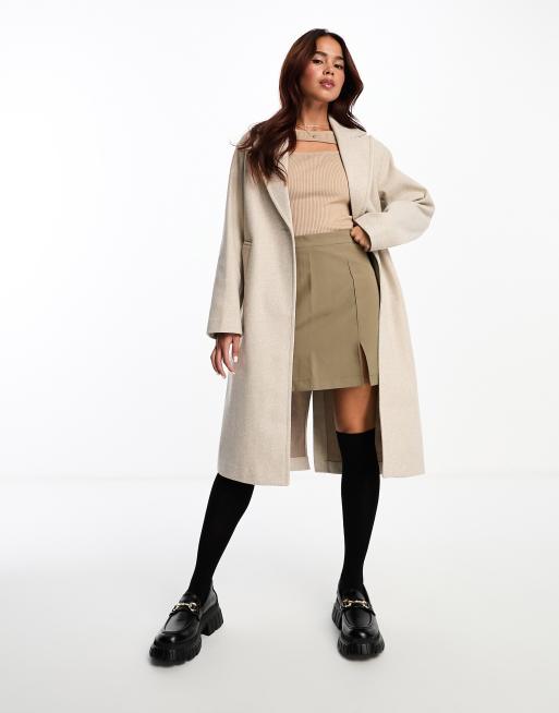 Mode femme casual avec un jogging noir, un long manteau noir et des baskets  blanche