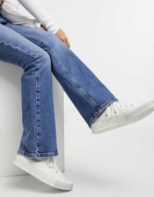 Flared jeans met store sneakers