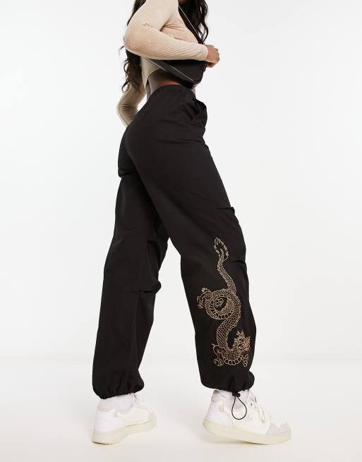 New Look – Svarta fallskärmsbyxor med broderad drake, 3 av 4