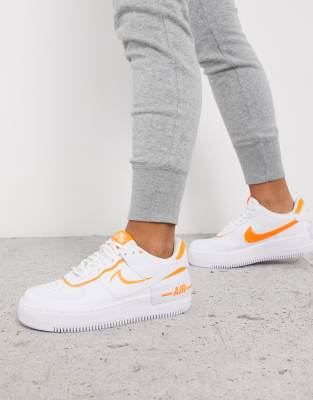 white nike trainers with orange tick