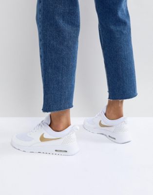 white nike trainers gold tick
