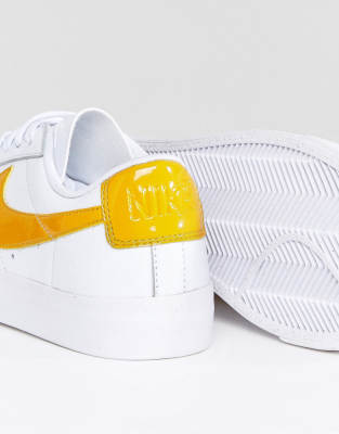 white and yellow nike trainers