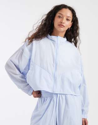 Nike - Cropped-Windjacke mit Stehkragen in Hellblau