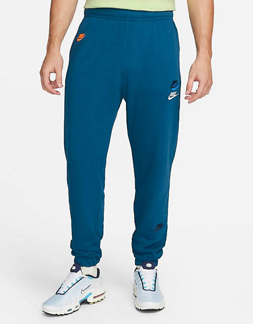 Nike Essentials fleece multi logo casual fit cuffed joggers in blue | ASOS