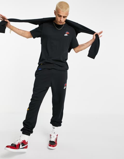 Nike – Essentials+ – T-Shirt mit mehreren Logos in Schwarz