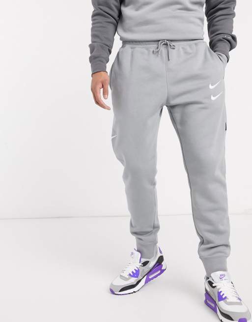 Nike - Jogger en polaire à logo virgule - Gris