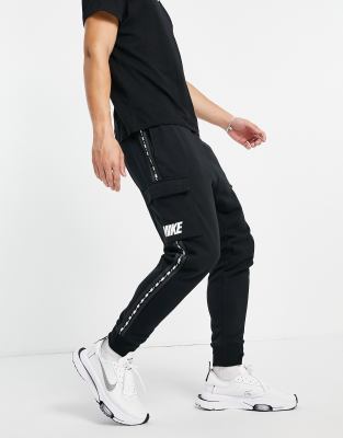Nike Jogger cargo en polaire avec bande à logo répété Noir ASOS