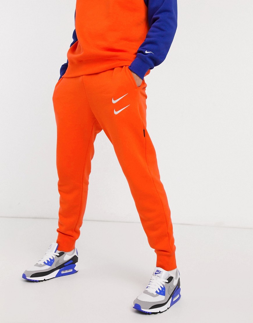 Nike - Joggers arancioni con logo Nike e fondo elasticizzato-Arancione