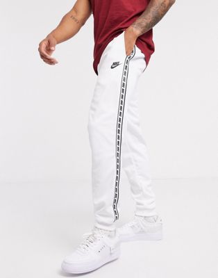 Nike logo taping cuffed polyknit joggers in white