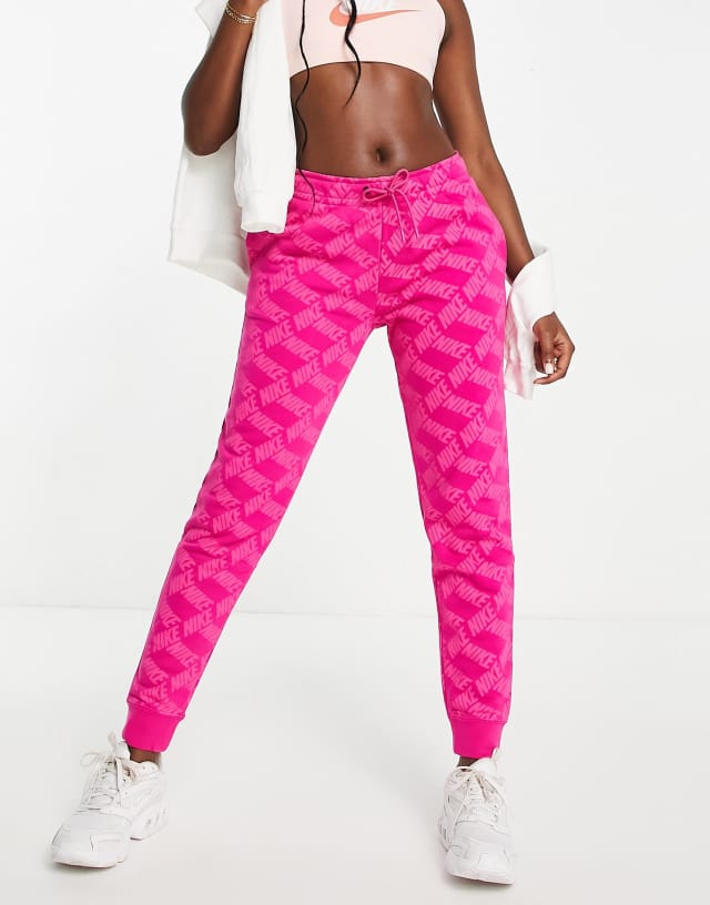 Nike monogram all over logo print fleece cuffed sweatpants in pink - PINK