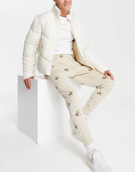 Nike monogram print sweatpants in beige - BEIGE